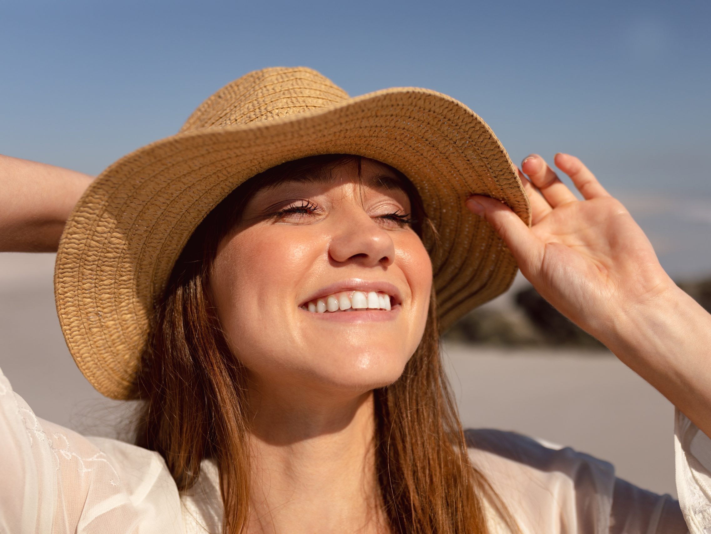 Tratamiento para manchas solares. Mujer joven al sol con manchas solares en la piel – Cómo eliminar las manchas solares